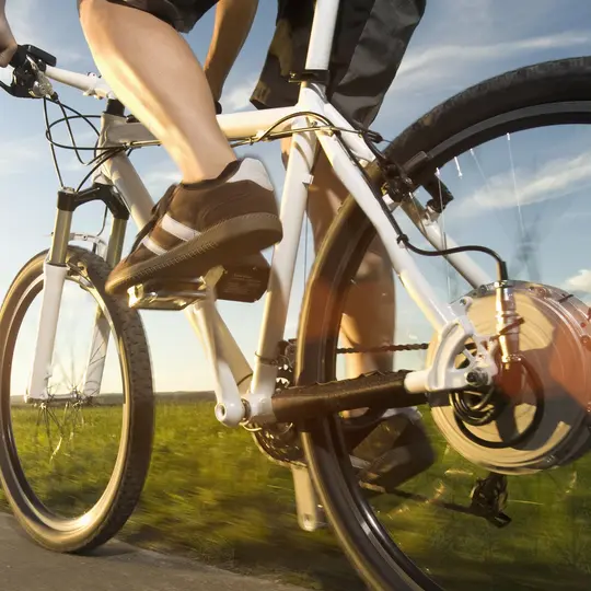 Man bicycling toward wind turbines.